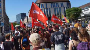 Demonstrationszug zum 1. Mai durch die Kieler Innenstadt. Es sind zahlreiche Fahnen der Partei "Die Linke" zu sehen.