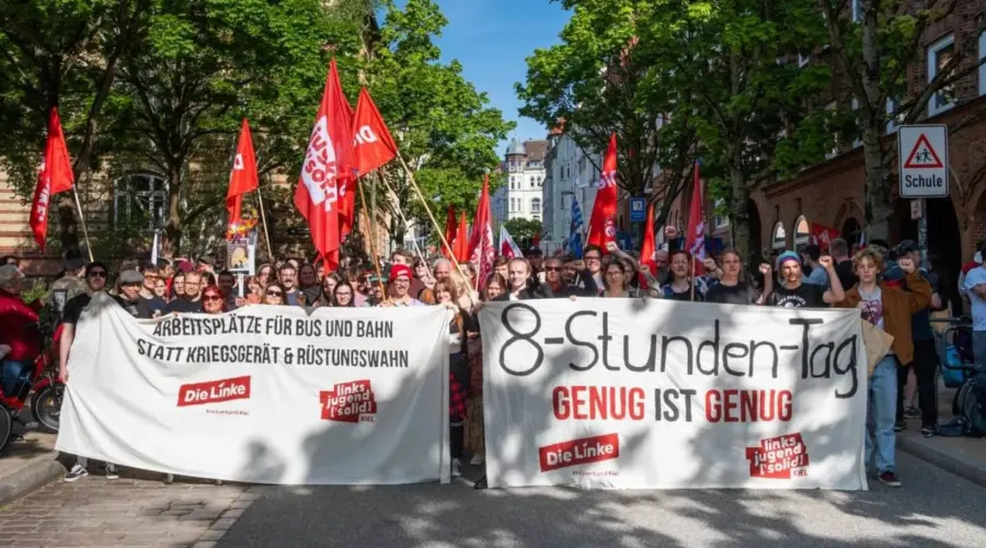 Die Truppe der Kieler Linken und der Kieler Linksjugend ['solid] hinter Transparenten, dazu viele rote Fahnen.