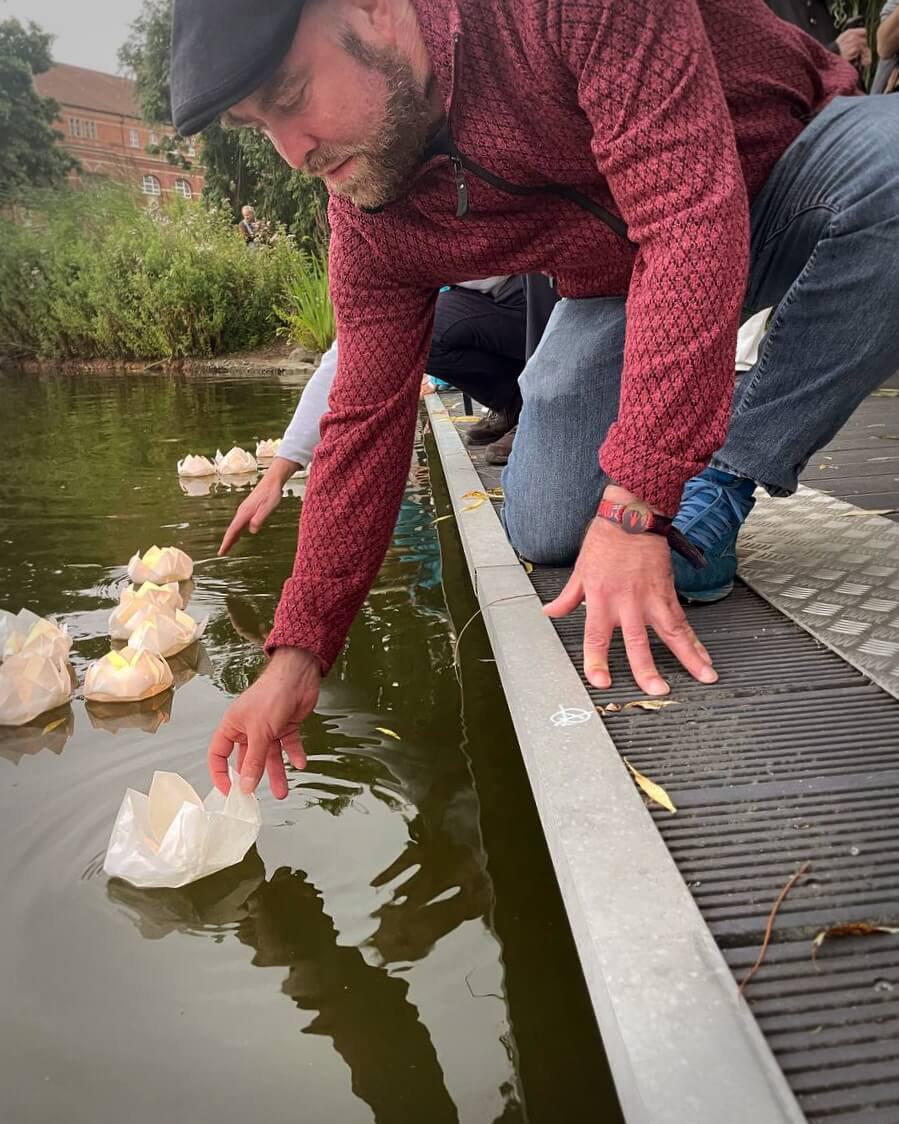 Björn Thoroe lässt beim Lotosblütenfest anlässlich des Hiroshima-Gedenkens am 06. August 2025 eine Lotosblüte aus Papier zu Wasser.