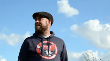 Porträt von Björn Thoroe vor blauem Himmel.