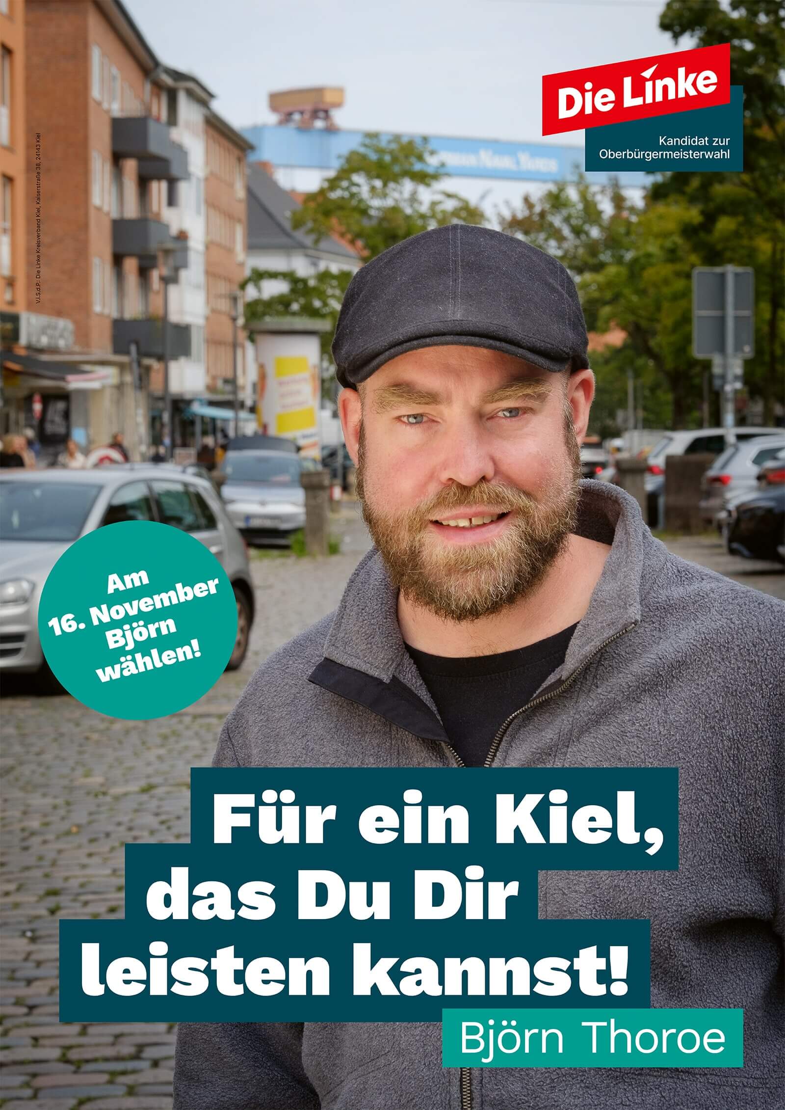 Das Wahlplakat zeigt den Kandidaten Björn Thoroe vor einer Straßenansicht in der Elisabethstraße in Kiel-Gaarden, im Hintergrund der markante Kran einer Kieler Werft. Das Plakat enthält zudem folgenden Text: Die Linke, Kandidat zur Oberbürgermeisterwahl. Für ein Kiel, das Du Dir leisten kannst! Am 16. November Björn wählen!
