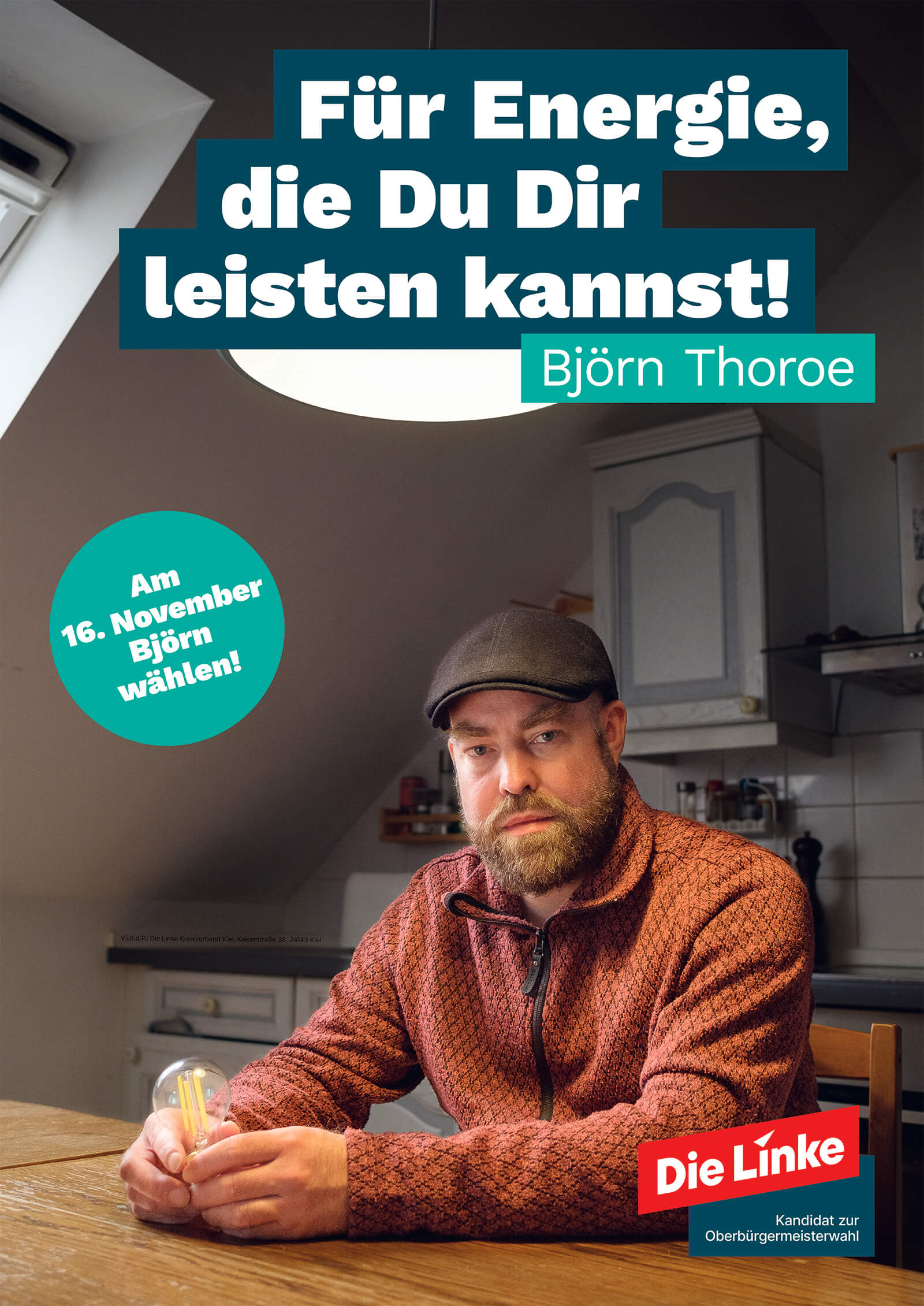 Das Wahlplakat zeigt den Kandidaten Björn Thoroe an einem Küchentisch, im Hintergrund die Küchenzeile. Er hält eine LED-Leuchtbirne in den Händen. Das Plakat enthält zudem folgenden Text: Die Linke, Kandidat zur Oberbürgermeisterwahl. Für Energie, die Du Dir leisten kannst! Am 16. November Björn wählen!