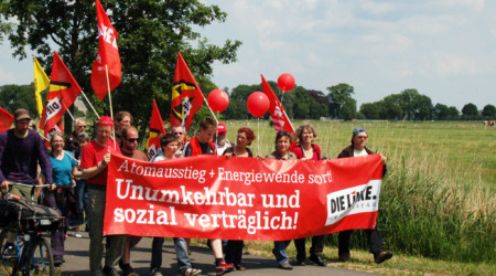 Björn Thoroe bei einer Anti-Atom-Demo in Brokdorf im Juni 2011. Zusammen mit anderen Personen hält er ein rotes Transparent mit folgender Aufschrift: "Atomausstieg & Energiewende sofort! Unumkehrbar und sozial verträglich! DIE LINKE."