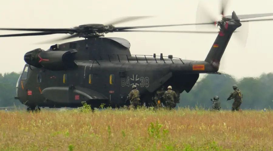 Zu sehen sind Bundeswehr-Soldaten, die auf einen Transport-Hubschrauber des Heeres zulaufen (während einer Übung).