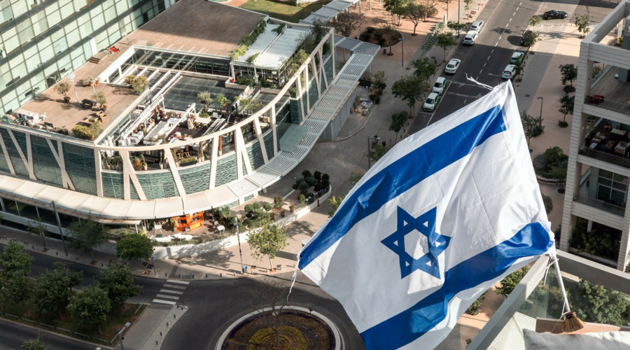 Die Flagge Israels über einer urbanen Straßenszene.