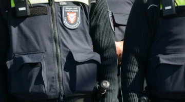 Zu sehen sind Uniformen mit der Aufschrift "Bürger- und Ordnungsamt Landeshauptstadt Kiel", am Gürtel Teleskop-Schlagstöcke.