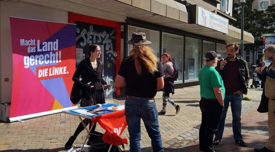 Mehrere Personen stehen an einem Infostand der Partei DIE LINKE.