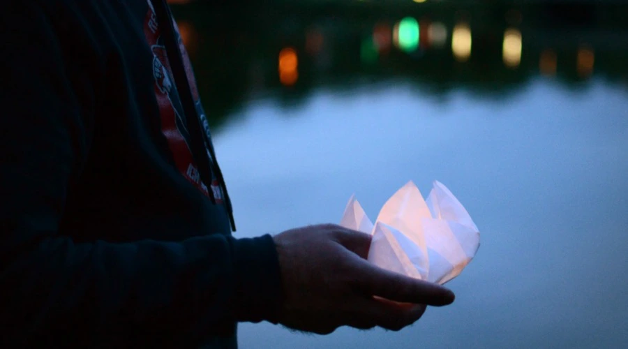 Björn Thoroe beim Lotusblütenfest am 06. August 2019, in der Hand eine Lotusblüte aus Papier, welche durch ein Teelicht erleuchtet wird.