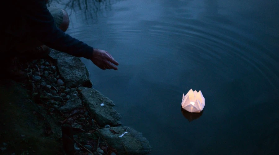 Björn Thoroe beim Lotusblütenfest am 06. August 2019, lässt eine Lotusblüte aus Papier zu Wasser.