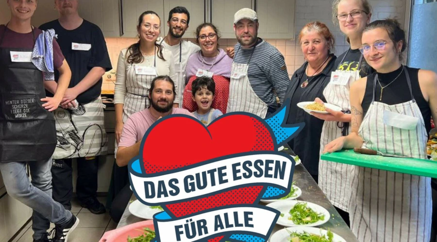 Das Koch-Team von DIE LINKE. Kiel bei der Aktion "Mahlzeit Gaarden" in der Sozialkirche Gaarden, darunter Tamara Mazzi und Björn Thoroe. Im Vordergrund ein stilisiertes Herz, welches von folgendem Text umschwungen wird: Das Gute Essen für alle!