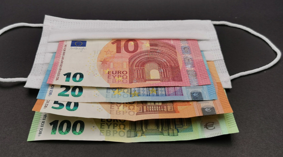 Auf einer Maske liegen Euro-Banknoten mit den Nennwerten 10, 20, 50, 100.