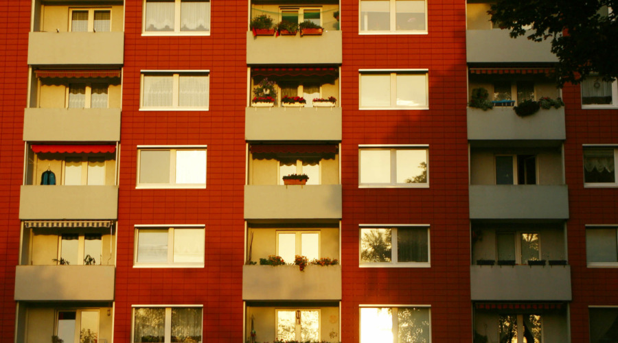 Eine Häuserfassade mit zahlreichen Fenstern und Balkonen.