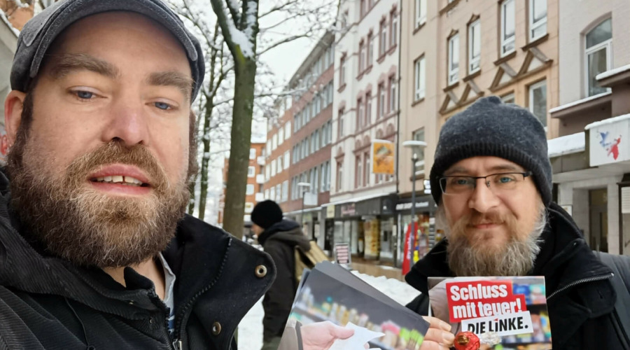 Björn Thoroe und ein Mitstreiter verteilen in Kiel-Gaarden ein Flugblatt mit dem Titel "Schluss mit teuer!"