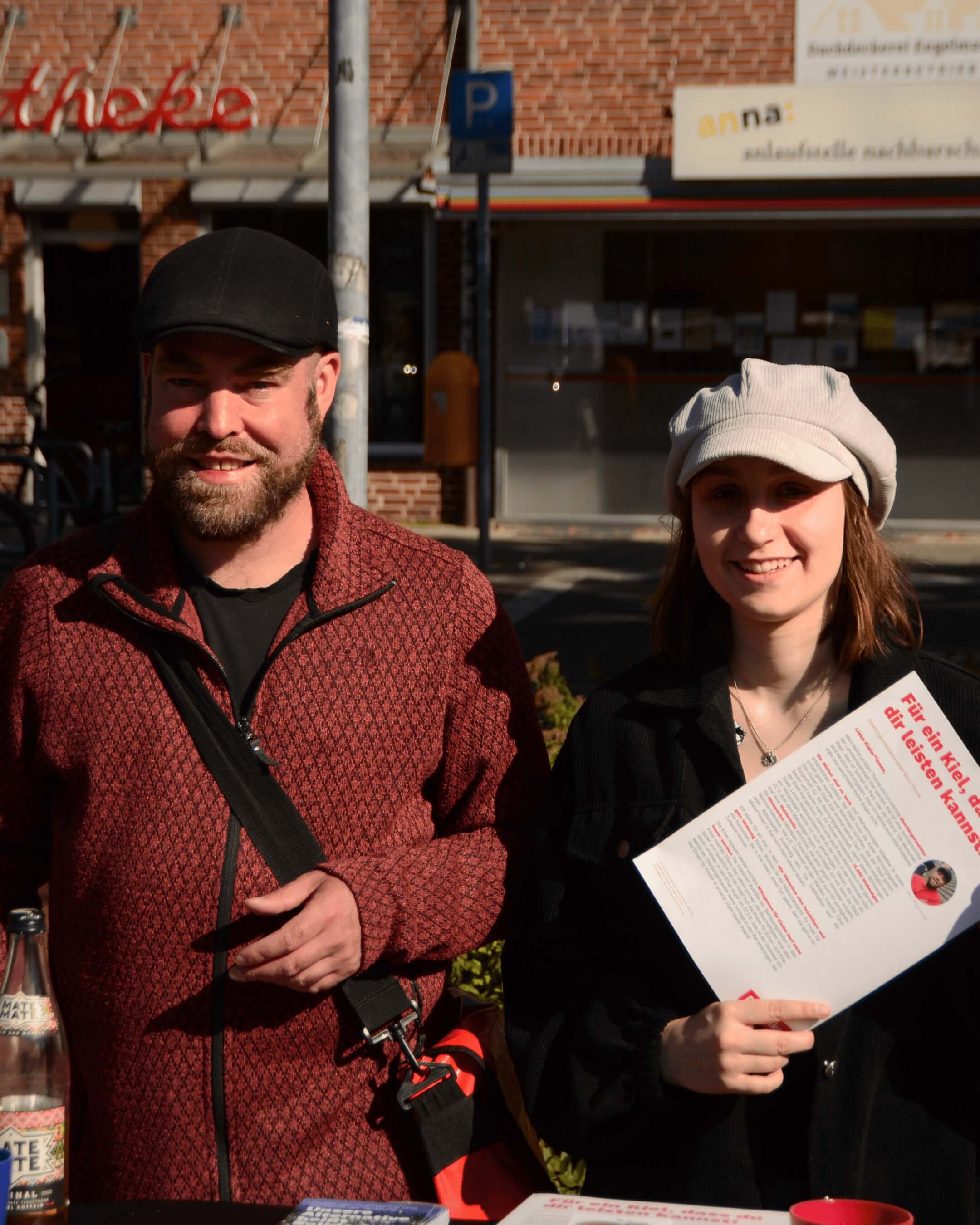 Björn Thoroe und eine junge Frau, die Flyer mit Björn drauf in der Hand hält.