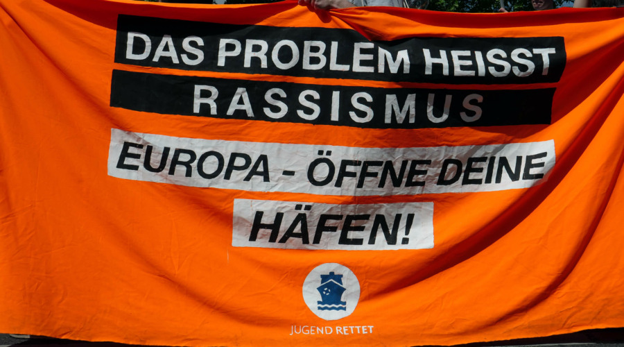 Demonstrations-Transparent mit Text: Das Problem heißt Rassismus. Europa - öffne Deine Häfen! Jugend rettet.