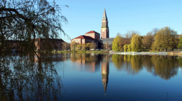 Der Kleine Kiel (ein Teich) in Kiel, im Wasser spiegelt sich das im Hintergrund zu sehende Rathaus.