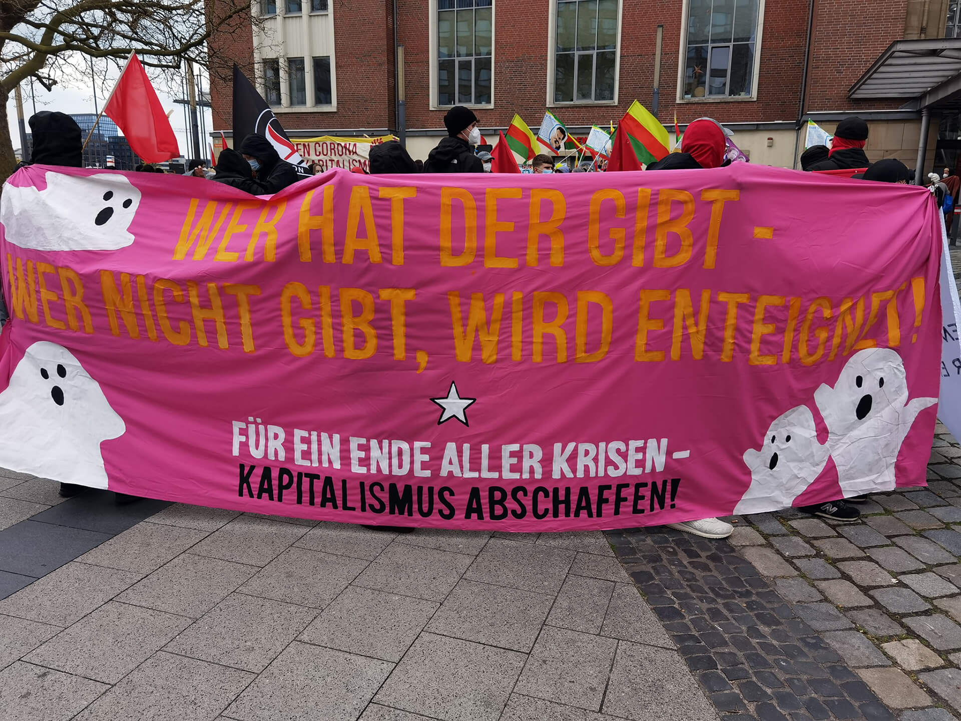 Transparent auf einer Demonstration mit folgender Aufschrift: Wer hat der gibt - Wer nicht gibt, wird enteignet! Für ein Ende aller Krisen - Kapitalismus abschaffen!