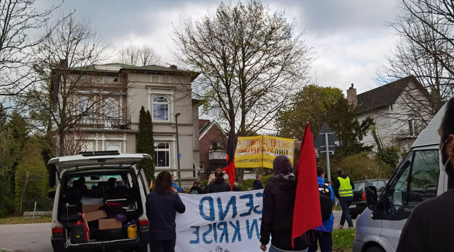 Eine Demonstration mit Roter Fahne vor einer Villa in Kiel-Düsternbrook.