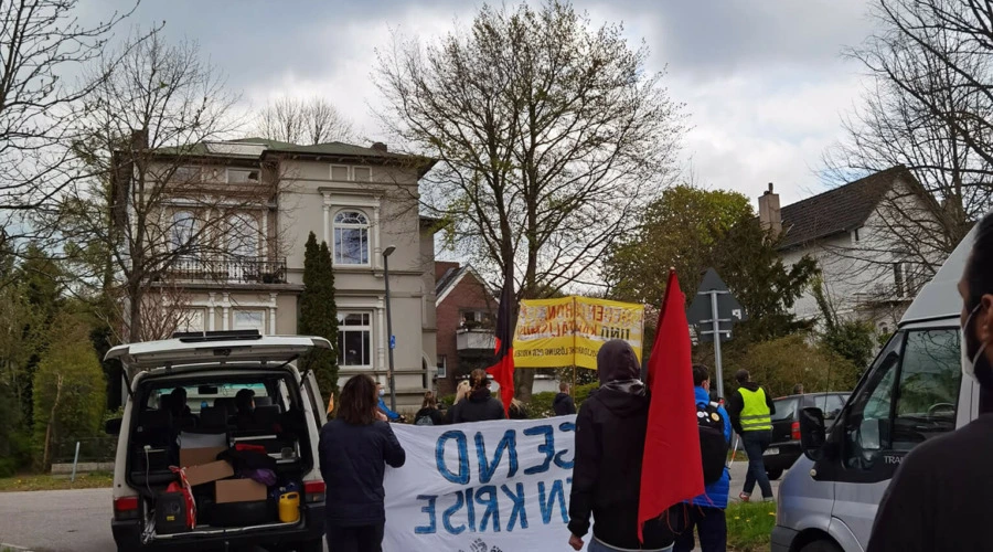 Eine Demonstration mit Roter Fahne vor einer Villa in Kiel-Düsternbrook.